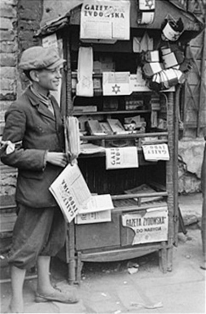 A teenage vendor sells newspapers and armbands in the Warsaw ghetto